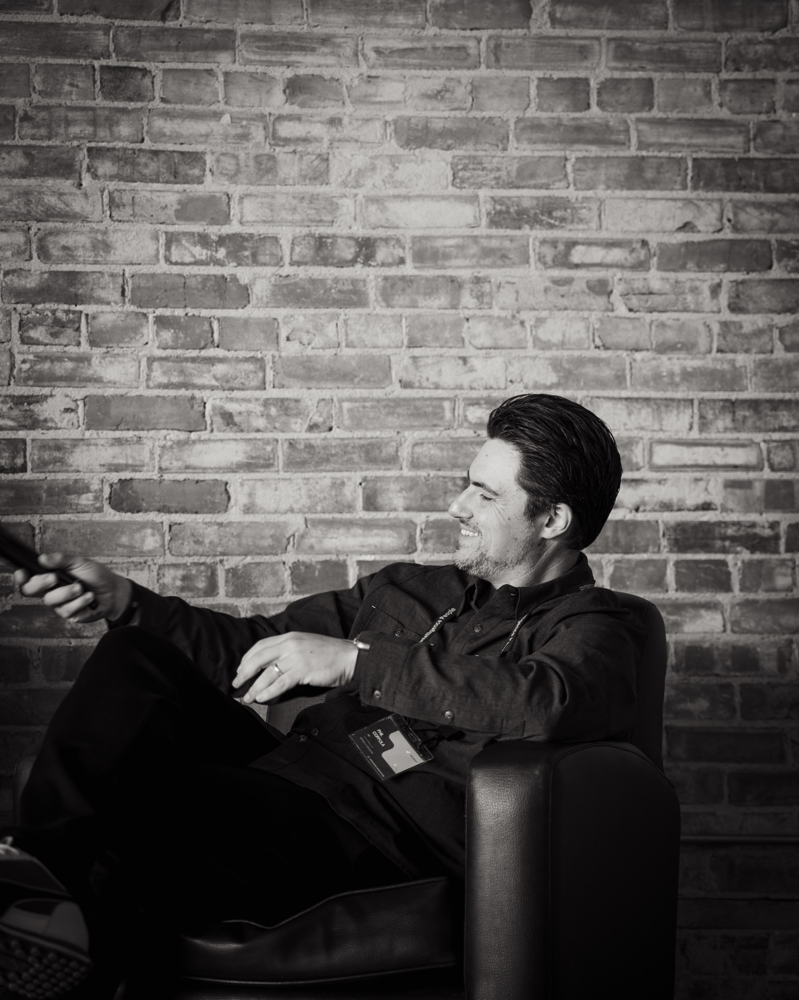 Phil Coppola seated in a lounge chair against a brick wall
